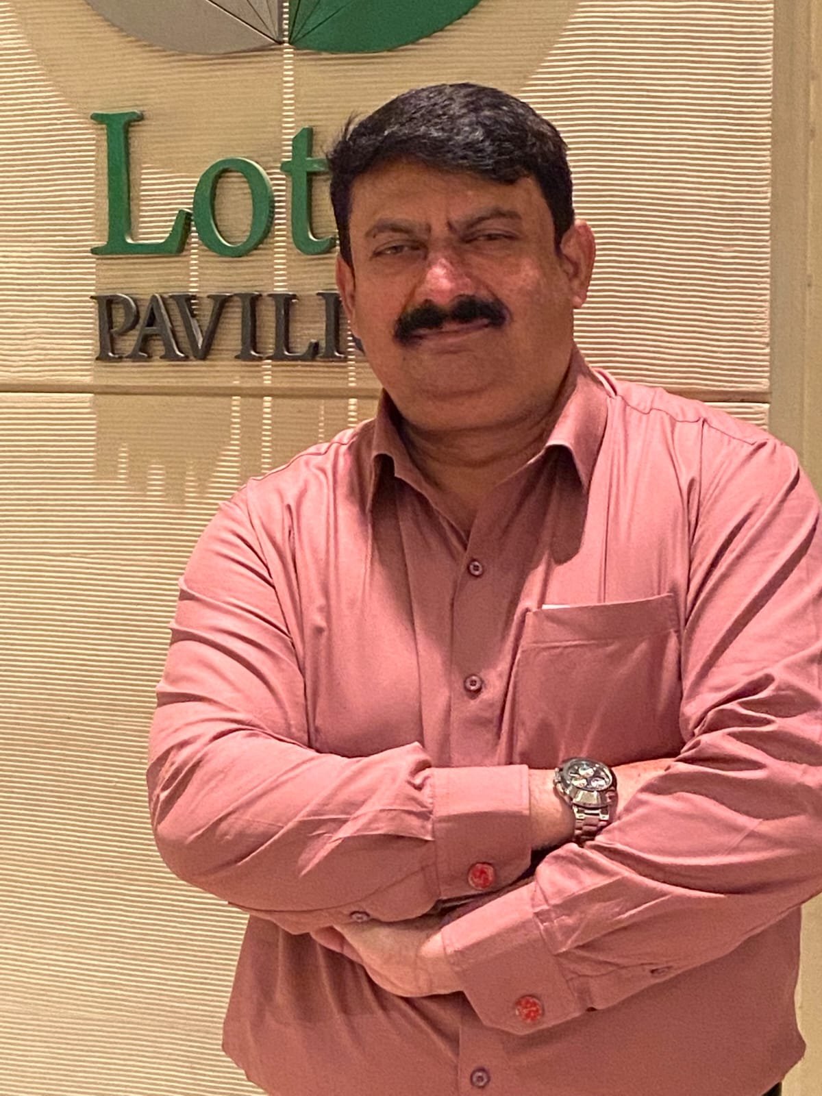 Gilani Sogi, Founder & CEO of Edison Lighting, smiling in a pink button-down shirt.
