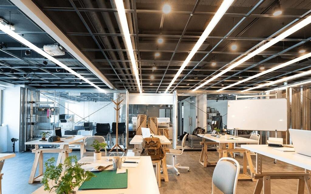 Modern office lighting with suspended LED linear lights for commercial workspace designed by Edison Lighting Bangalore.